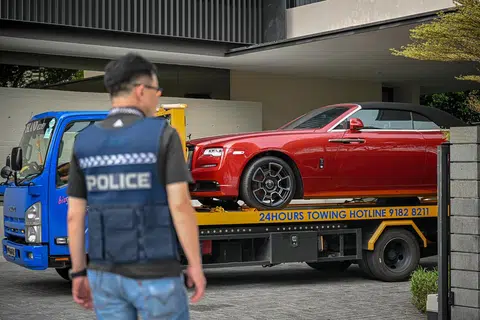 DIRAMPAS: Salah satu daripada empat kereta mewah yang dikaitkan dengan kes pengubahan wang haram terbesar di Singapura yang ditarik keluar dari sebuah Banglo Kelas Baik (GCB) di Third Avenue pada Rabu.