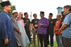 KERJASAMA DENGAN MASJID: Wakil Forum Belia Muslim (MYF) dan Masjid Al-Firdaus sedang berbincang mengenai acara jamuan makan untuk 1,000 pekerja asing yang bakal diadakan di masjid Choa Chu Kang itu pada 31 Disember nanti. - Foto BH oleh CHONG JUN LIANG