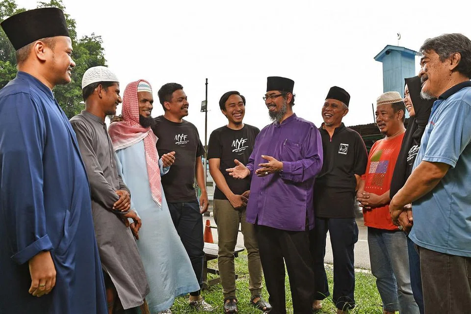 KERJASAMA DENGAN MASJID: Wakil Forum Belia Muslim (MYF) dan Masjid Al-Firdaus sedang berbincang mengenai acara jamuan makan untuk 1,000 pekerja asing yang bakal diadakan di masjid Choa Chu Kang itu pada 31 Disember nanti. - Foto BH oleh CHONG JUN LIANG