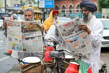 Sekumpulan lelaki membaca akhbar tempatan yang memaparkan tajuk utama mengenai konflik India-Pakistan di Amritsar pada 8 Mei 2025, sehari selepas India melancarkan serangan ke atas Pakistan. 