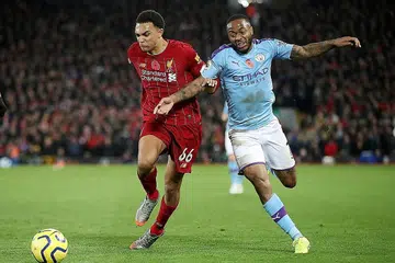 DIJANGKA DIMULAKAN SEMULA JUN: Peminat Liga Perdana England dijangka dapat menonton semula pemain kelab Liverpool seperti Tren Alexander-Arnold (jersi merah) dan penyerang Manchester City Raheem Sterling (jersi biru) beraksi dalam pertandingan EPL seawal Jun nanti. - Foto REUTERS