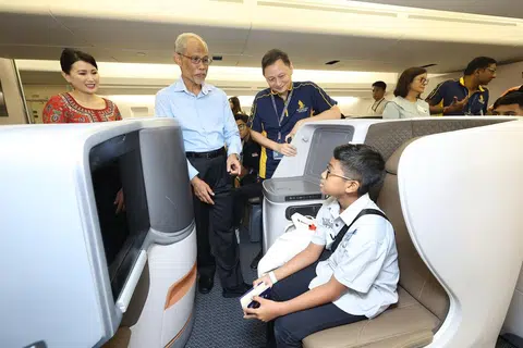 TINJAU KABIN PESAWAT: Menteri Pembangunan Sosial dan Keluarga, Encik Masagos Zulkifli Masagos Mohamad (kemeja biru) dan Ketua Pegawai Eksekutif SIA, Encik Goh Choon Phong (berbaju polo) kelihatan berinteraksi dengan salah seorang peserta lawatan dalam model kabin Kelas Bisnes.