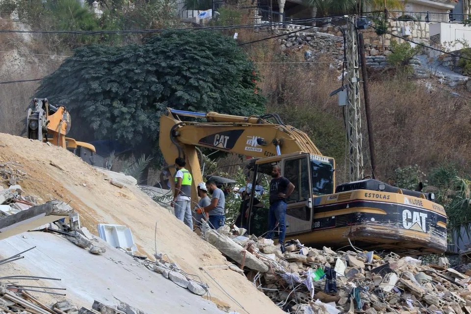 Pasukan penyelamat menggali runtuhan bangunan, sehari selepas ia berhadapan serangan Israel, di perkampungan Ain El Delb di selatan Lebanon pada 30 September 2024. 