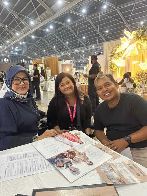 Bakal pengantin, Encik Herman Abdullah (kanan) dan Cik Roszana Ali (tengah) mengunjungi pameran pengantin untuk berjumpa dengan usahawan terkemuka, Cik Fatimah Mohsin (kiri).