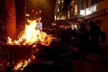Pasukan polis anti rusuhan Perancis bersemuka dengan penunjuk perasaan yang membakar longgokan sampah di Paris, Perancis.