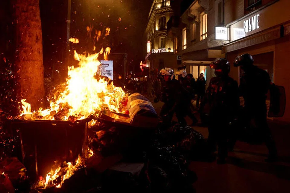 Pasukan polis anti rusuhan Perancis bersemuka dengan penunjuk perasaan yang membakar longgokan sampah di Paris, Perancis.