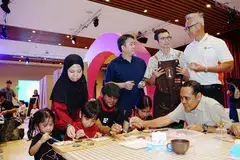 Menteri Negara (Pembangunan Sosial dan Keluarga merangkap Ehwal Luar), Encik Zhulkarnain Abdul Rahim (kanan, duduk), meluangkan masa berinteraksi dan mencuba aktiviti melukis tanah liat bersama keluarga Cik Norasma’ Sapari (kiri, diri) semasa Festival Play It Forward 2026 di Pusat Kebudayaan Cina Singapura pada 13 Jun. Bersama dalam gambar (dari kiri, duduk) Noriysha Norhaizat; Norizadin Norhaizat; Norishlah Norhaizat dan Encik Norhaizat Mohamed Noor. (Dua dari kiri, diri) CEO KidSTART Singapore, Encik Joel Tan; Pengarah Gmaximus, Encik Valerian Loke; dan Pengarah Urusan Community Chest, Encik Jack Lim.