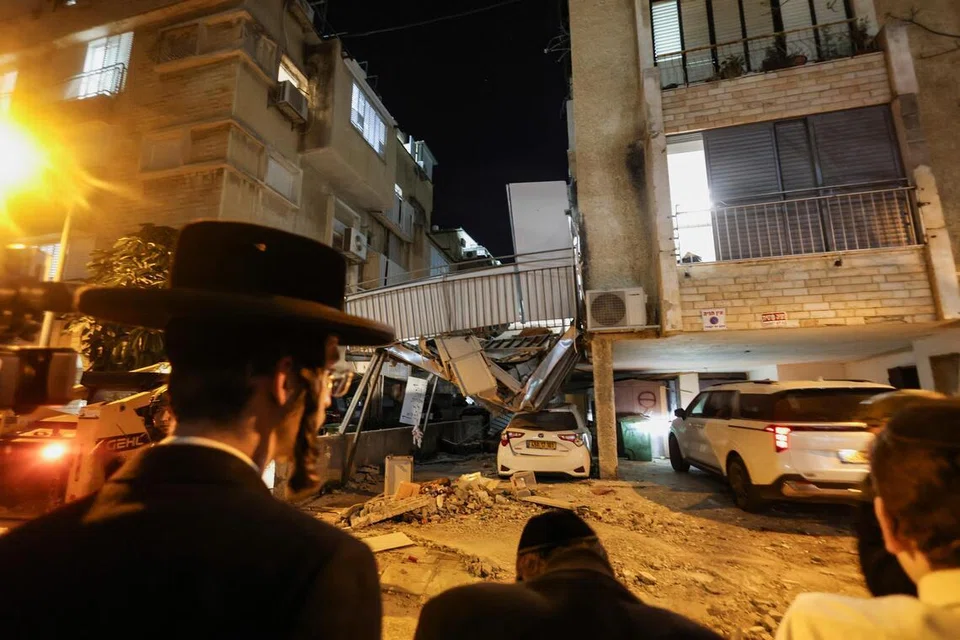 Orang ramai meninjau kesan kemusnahan susulan bedilan peluru berpandu Iran di kawasan tengah Israel pada 24 Mac 2026, ketika konflik antara Amerika Syarikat dan Israel dengan Iran terus memuncak, di tengah usaha Washington mengemukakan pelan 15 perkara bagi menamatkan perang di Timur Tengah.