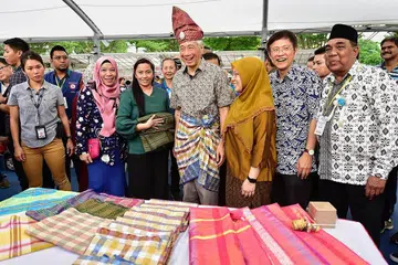 KENAKAN PAKAIAN MELAYU: Perdana Menteri Encik Lee Hsien Loong (empat dari kanan) mengambil kesempatan mengenakan tanjak dan samping sebagai antara kegiatan Karnival Aidilfitri. Turut menemani beliau ialah Anggota Parlimen GRC Ang Mo Kio, Cik Intan Azura Mokhtar (tiga dari kanan) dan Encik Gan Thiam Poh (dua dari kanan) - Foto BH oleh DESMOND WEE