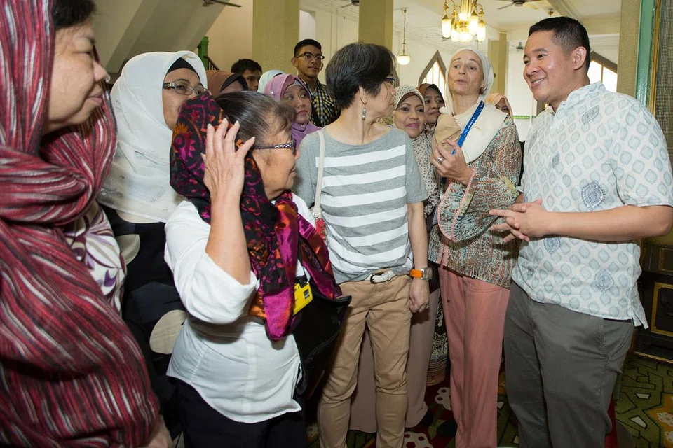 PELAJARI WARISAN DAN SEJARAH MASJID SULTAN: Encik Amrin (kanan) bersama beberapa peserta Jejak Warisan mendengar penjelasan daripada seorang jurupandu sukarela, Cik Atika Salbine Lopez (dua dari kanan) mengenai sejarah dan warisan masjid itu. - Foto QOMARUL ARIFIN