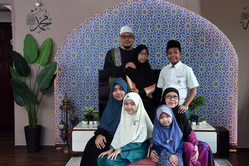 BERKAT USAHA TEKAL: Keputusan cemerlang, sokongan dan dorongan ibu bapa serta didikan guru memberi Umar Rasyideen (bersongkok hitam) motivasi untuk bekerja keras. Dia bersama (ikut putaran jam) bapa Mohamed Salehin Mohamed Deros, adik Aisyah Maisarah, nenek Nooriya Mohamed, adik Afifah, adik Sofwah Assolehah, dan ibu Nurul Jannah Ayob. - Foto BH oleh DESMOND FOO