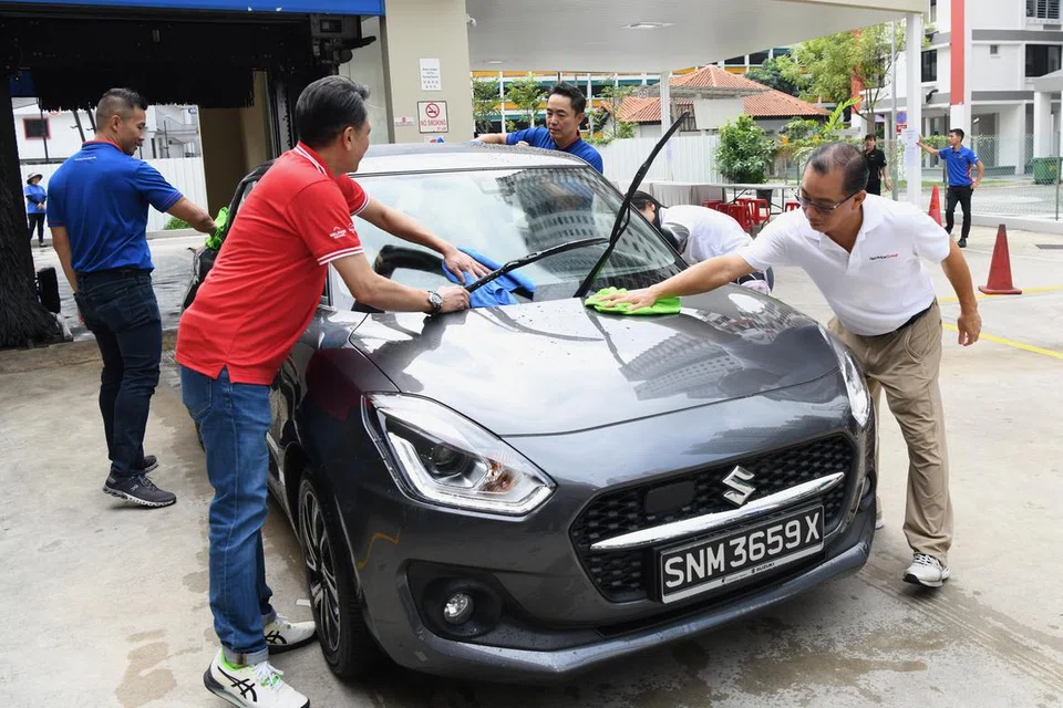 CUCI KERETA AMAL: Encik Seah Kian Peng, CEO Kumpulan NTUC Enterprise, dan Speaker Parlimen (pertama dari kanan), bersama pasukan pengurusan FairPrice, Cheers and Children’s Aid Society serta sukarelawan yang mengambil bahagian dalam aktiviti mencuci kereta.