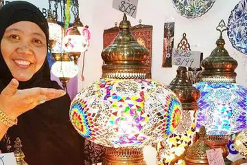 TUMPUAN TERHADAP LAMPU: Tetamu yang datang ke rumah pasti akan tertarik dengan hiasan lampu ala mozek yang dijual di gerai Cik Hamsiah Ja'afar di bazar Paya Lebar. - Foto SHAHIDA SARHID