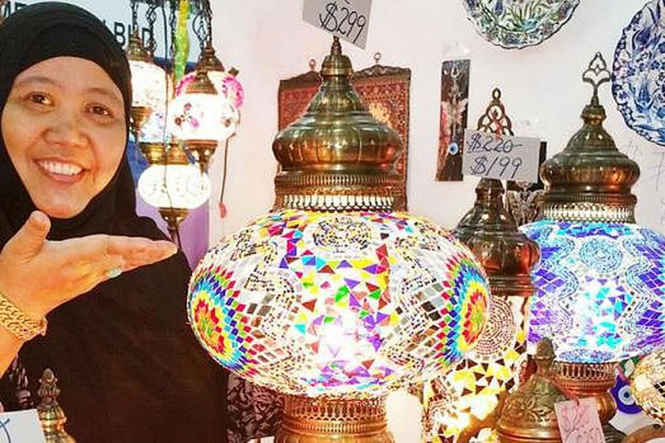 TUMPUAN TERHADAP LAMPU: Tetamu yang datang ke rumah pasti akan tertarik dengan hiasan lampu ala mozek yang dijual di gerai Cik Hamsiah Ja'afar di bazar Paya Lebar. - Foto SHAHIDA SARHID