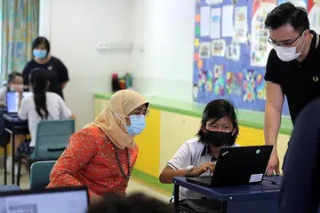 LAWAT SEKOLAH: Presiden Halimah gesa lebih ramai warga menjadi relawan semasa kunjungannya di Sekolah Rendah Choa Chu Kang. Dalam gambar adalah pelajar Alya Qalysa Abdullah (tengah) dan relawan mentor Encik Ugine Chua (kanan). - Foto MCI