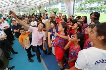 INISIATIF UNTUK BELIA: Menteri Kanan merangkap Menteri Penyelaras bagi Dasar Sosial, Encik Tharman Shanmugaratnam (berbaju coklat) bergambar bersama pemain bola sepak wanita Tasek Sailors di Pusat Latihan Lion City Sailors pada Ahad.