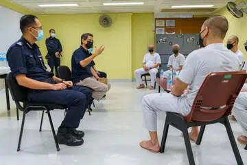 BANDUAN PERLU DISOKONG BAGI MULA HIDUP BARU: Profesor Madya Muhammad Faishal Ibrahim (duduk, dua dari kanan) bertemu dengan para pesalah di penjara baru-baru ini sebelum berbuka puasa bersama mereka. - Foto PERKHIDMATAN PENJARA SINGAPURA