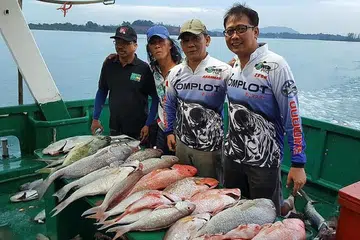 RAIH HASIL TANGKAPAN: Encik Zecha Churimi (kanan) bersama anggota kumpulan Komplot bergambar bersama ikan-ikan yang mereka pancing semasa berada di Tanjung Pinang. - Foto-foto ihsan ZECHA CHURIMI