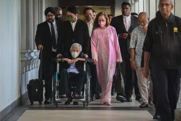 HADAPI DAKWAAN: Mantan Menteri Kewangan Tun Daim Zainuddin, yang berkerusi roda, ditemani isterinya Toh Puan Na’imah Abdul Khalid hadir di Kompleks Mahkamah Kuala Lumpur bagi menghadapi tuduhan berhubung gagal mematuhi notis dengan tidak mengisytiharkan harta di Mahkamah Sesyen pada 29 Januari.