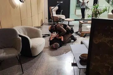 DITANGKAP: Seorang remaja berpakaian baju hitam dan topi, yang dipercayai adalah penembak dalam kejadian di Siam Paragon itu, disekat oleh seorang pegawai polis.