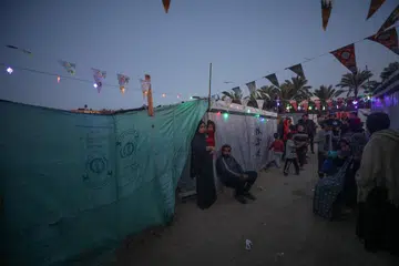 Penduduk berada di sebuah kem untuk penduduk Palestin yang kehilangan tempat tinggal di Rafah, di selatan Jaluran Gaza, pada malam 10 Mac di tengah-tengah pertempuran berterusan di antara Israel dengan Hamas 