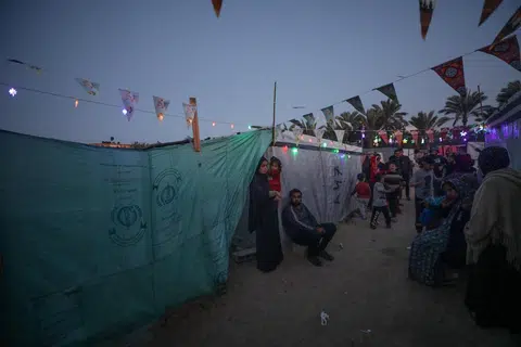 Penduduk berada di sebuah kem untuk penduduk Palestin yang kehilangan tempat tinggal di Rafah, di selatan Jaluran Gaza, pada malam 10 Mac di tengah-tengah pertempuran berterusan di antara Israel dengan Hamas 