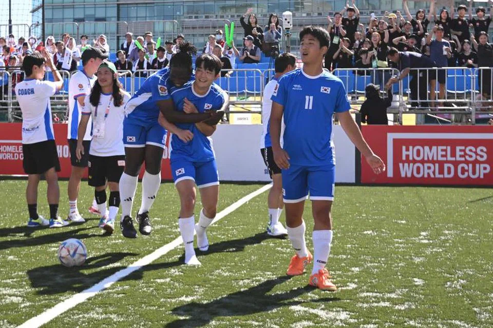 Pelarian Cameroon, Fossi Wandji (kiri, sedang melompat) meraikan kemenangan bersama rakan sepasukan selepas perlawanan antara Korea Selatan dengan Switzerland.