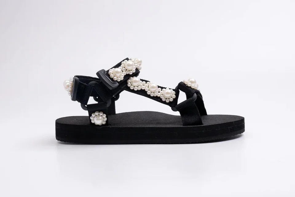 ‘White Pearly Jaedals’ ($99) dihiasi mutiara halus untuk gaya santai yang tetap menawan. Setiap pembelian turut menyokong inisiatif sosial serta usaha kelestarian alam sekitar.