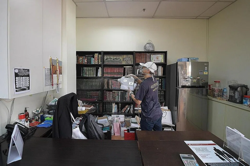 SESUAIKAN DENGAN SITUASI: Seorang pekerja 4riz Services Pte Ltd menjalankan kerja pembasmian kuman di pejabat pelanggan di Changi Road. Syarikat perkhidmatan pemindah itu kini memberi lebih tumpuan pada perkhidmatan pembasmian kuman kerana dalam tempoh ini ia tidak dapat menerima banyak tempahan bagi perkhidmatan pemindah. - Foto BH oleh ALPHONSUS CHERN