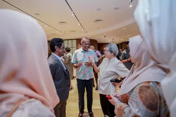 BERAMAH MESRA: Menteri Ehwal Dalam Negeri merangkap Undang-Undang, Encik K. Shanmugam (tengah) dan Presiden Pertubuhan Antara Agama (IRO), Encik Noor Marican (kiri), berinteraksi dengan hadirin di satu tayangan dokumentari anjuran IRO pada Rabu.