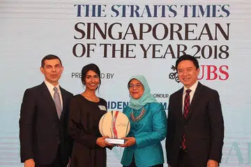 TERIMA PENGIKTIRAFAN: Cik Siti Noor Mastura (dua kiri) terima anugerah Tokoh Singapura The Straits Times 2018 daripada Presiden Halimah. Kiri Ketua Editor Kumpulan Media Inggeris, Melayu, Tamil (EMTM) Singapore Press Holdings (SPH) yang juga Editor The Straits Times, Encik Warren Fernandez. Kanan ialah Encik Edmund Koh, Presiden Asia Pacific UBS Group AG dan UBS AG. - Foto BH oleh TIMOTHY DAVID