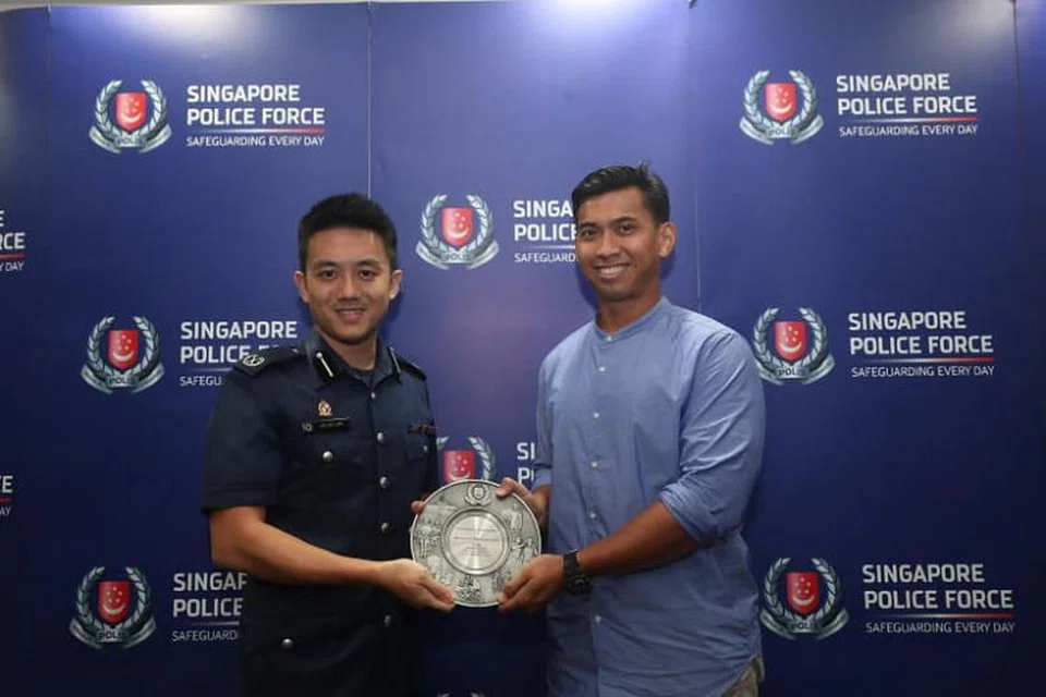 Encik Khairil Anwar Tahir (kanan) menerima Anugerah Semangat Kemasyarakatan Awam yang disampaikan Komander Divisyen Polis Bedok Julius Lim. FOTO: TIMOTHY DAVID