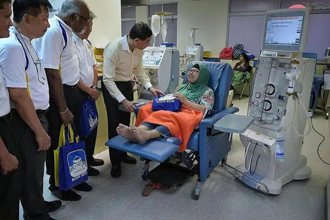 HULUR BANTUAN: Ketua pegawai eksekutif ComfortDelGro Taxi Ang Wei Neng menyantuni Cik Nor Aisah semalam. Mereka diiringi pemandu teksi kumpulan CabbyCare. - Foto BH oleh KUA CHEE SIONG
