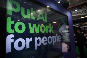 aparan bertulis “Put AI to work for people” (Manfaatkan AI untuk manusia) ketika London Tech Week di Olympia, London, pada 8 Jun 2026. Kerajaan Britain merancang memperketat penggunaan kecerdasan buatan (AI) dalam teknologi penghasilan DNA sintetik susulan kebimbangan ia boleh disalahgunakan oleh pengganas atau pihak tidak bertanggungjawab untuk menghasilkan bahan biologi berbahaya. Antara langkah yang dipertimbangkan ialah mewajibkan makmal menyaring pelanggan dan tempahan urutan DNA yang mencurigakan.