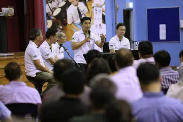 MEMBINA KELUARGA BERDAYA TAHAN: Menteri Pembangunan Sosial dan Keluarga, Encik Tan Chuan-Jin (berdiri), berdialog dengan lebih 200 bapa dalam forum di Sekolah Rendah Northland yang julung kali diadakan dalam acara anjuran Pusat Kebapaan (CFF) dan pergerakan Bapa Sepanjang Hayat (DFL). Panel lain termasuk (dari kiri) pengasas bersama CFF, Encik Edwin Choy; sukarelawan DFL yang juga mentor kumpulan bapa, Encik Tio Chong Heng; pengasas DFL, Encik Jason Wong; serta ketua pegawai eksekutif CFF, Encik Bryan Tan. - Foto THE STRAITS TIMES