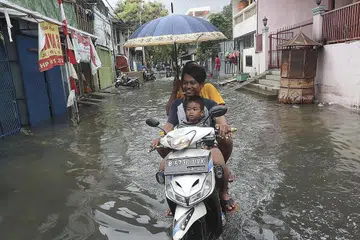BANJIR BESAR: Penduduk menunggang motosikal melalui jalan yang banjir di Jakarta pada 5 Januari lalu. Banjir yang melanda Jakarta dan bandar-bandar berdekatan telah membunuh sekurang-kurangnya 60 orang, dan menjejas ratusan ribu orang. - Foto AP