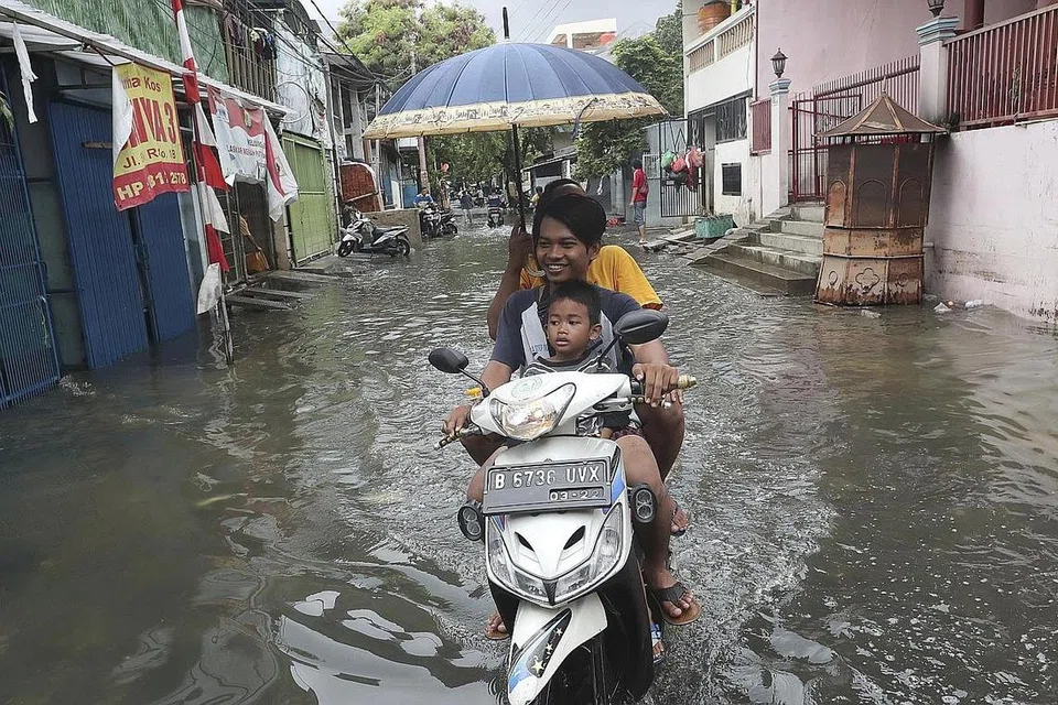 BANJIR BESAR: Penduduk menunggang motosikal melalui jalan yang banjir di Jakarta pada 5 Januari lalu. Banjir yang melanda Jakarta dan bandar-bandar berdekatan telah membunuh sekurang-kurangnya 60 orang, dan menjejas ratusan ribu orang. - Foto AP