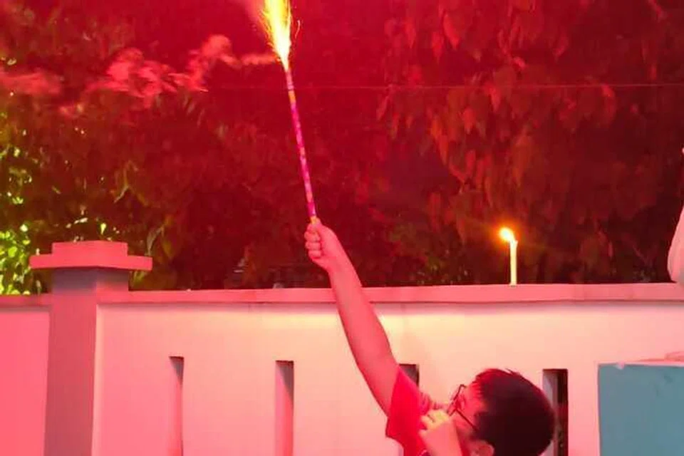 Anak lelaki Cik Juniati, Arzyq Shahrul bergembira sewaktu bermain bunga api. 