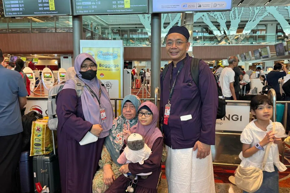 Pasangan suami isteri, Encik Mohammad Dzulkifli Mohyi Hapipi (kanan) dan Cik Zhalynda Abdul Rahim (kiri) memakai baju sedondon berwarna ungu dengan puteri mereka (dua dari kanan) agar dia juga dapat menikmati suasana persis jemaah haji yang bakal berlepas dengan seragam sedondon seperti ibu bapanya. 