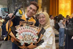 Rayyan Afiq Mohamed Azlin menerima jambangan yang dibuat daripada kepingan wang tunai, hadiah daripada ibunya, Cik Rozaida Mohamed Yusof (kanan) dan ayahnya, Encik Mohamed Azlin Manat, di atas kerja kerasnya dalam bidang perniagaan dan pengajiannya.