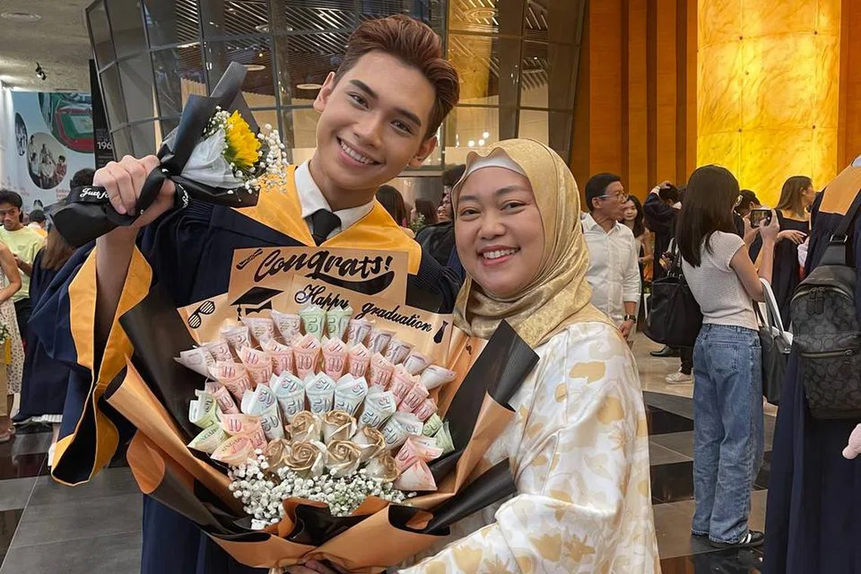 Rayyan Afiq Mohamed Azlin menerima jambangan yang dibuat daripada kepingan wang tunai, hadiah daripada ibunya, Cik Rozaida Mohamed Yusof (kanan) dan ayahnya, Encik Mohamed Azlin Manat, di atas kerja kerasnya dalam bidang perniagaan dan pengajiannya.