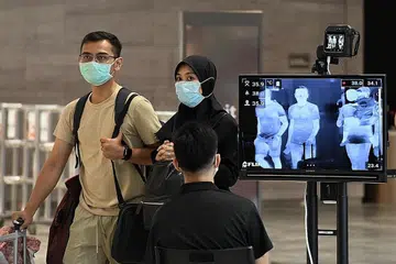 CEGAH KORONAVIRUS: Singapura meningkatkan daya tahan dan pengawalan secara menyeluruh bagi mengawal penularan koronavirus, dan antara langkah yang diambil adalah pemeriksaan suhu di Lapangan Terbang Changi. - Foto AFP
