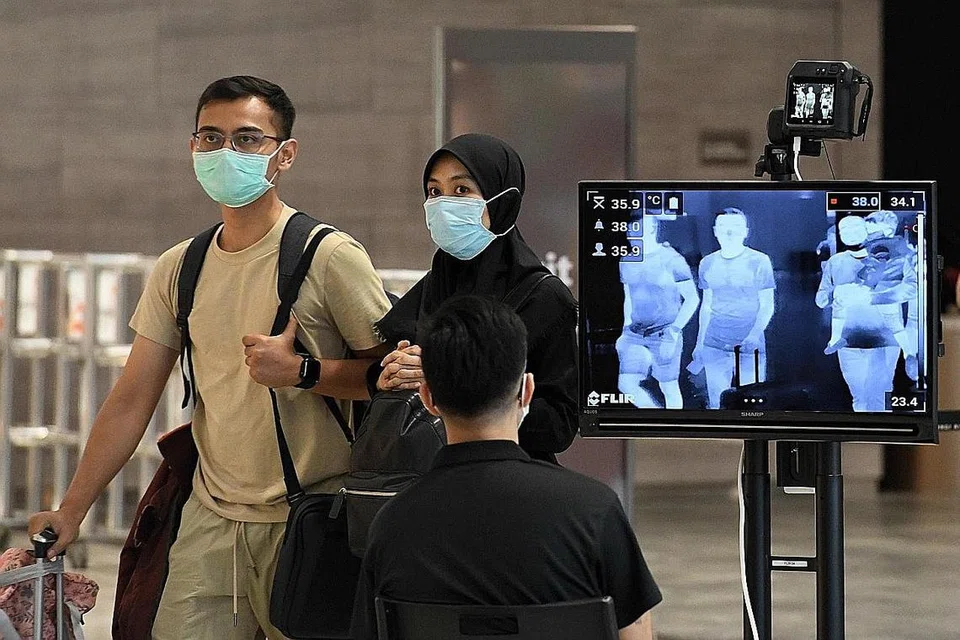 CEGAH KORONAVIRUS: Singapura meningkatkan daya tahan dan pengawalan secara menyeluruh bagi mengawal penularan koronavirus, dan antara langkah yang diambil adalah pemeriksaan suhu di Lapangan Terbang Changi. - Foto AFP