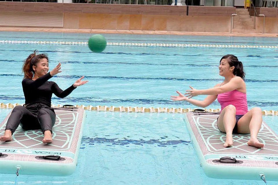 PERLU IMBANG BADAN: Penulis (kiri) mencuba senaman Hydrofit dengan pergerakan diadakan atas tikar khas terapung yang dinamakan BOGA FitMat. - Foto BH oleh KHALID BABA