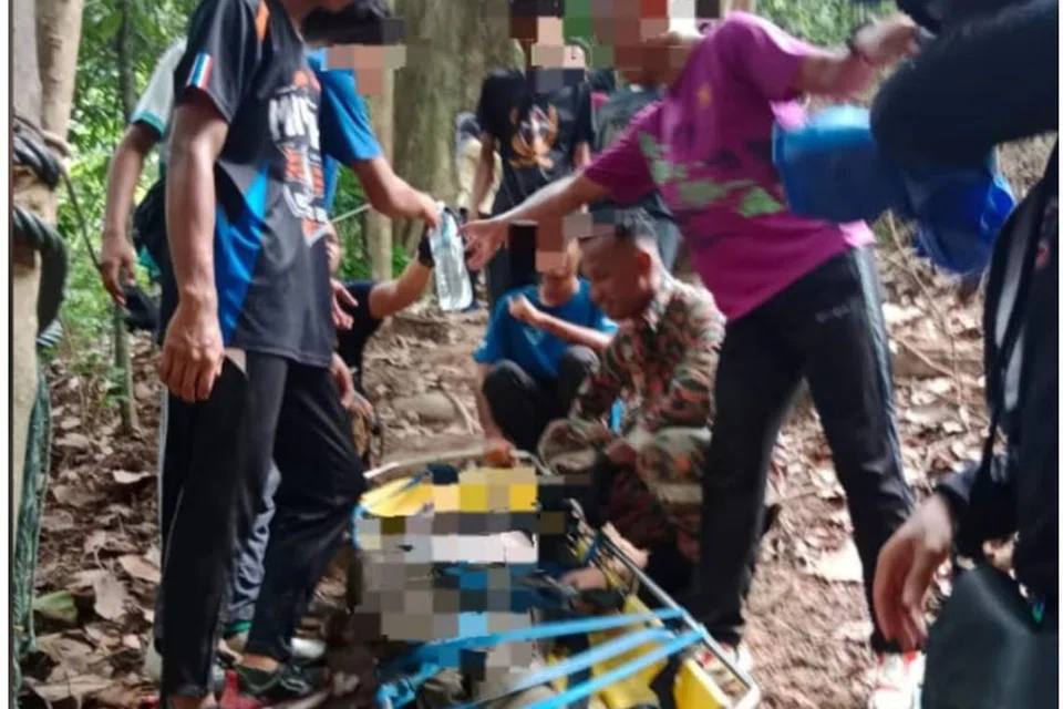 AKIBAT MERACAU: Mangsa dibawa turun menggunakan alat pengusung pada Ahad.