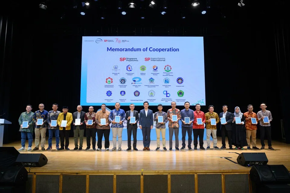 Menteri Negara (Perdagangan dan Perusahaan), Encik Alvin Tan (tengah, sut biru) di majlis pemeteraian Memorandum Kerjasama (MoC) antara Politeknik Singapura dan 17 Institut Pengajian Tinggi (IHL) Indonesia pada 17 Oktober di Pusat Konvensyen SP.
