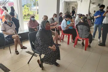 AMBIL DOS PENGGALAK: Cik Aminah Jumaat antara warga emas yang dilihat mengambil suntikan vaksin atau penggalak Covid-19 di pusat vaksin mudah alih di Nee Soon Central semalam.- Foto BH oleh NUR DHUHA ESOOF