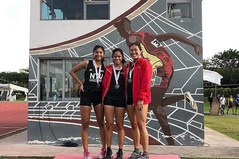 CATAT REKOD PERIBADI: Haanee (tengah) bergambar bersama pesaing lain, Tanishe Moghe (kiri) dan Gwendolyn Lim selepas perlumbaan pecut 100 meter puteri pada 11 Januari lalu. - Foto HAMKAH AFIK