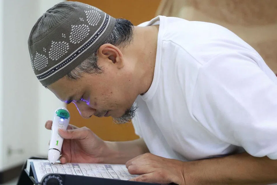 TERUS MENGAJI: Selepas penglihatannya kembali sekitar 30 peratus, Encik Mohamad Hasri memastikan beliau mengambil peluang tersebut untuk membaca Al-Quran. - Foto BH oleh GAVIN FOO