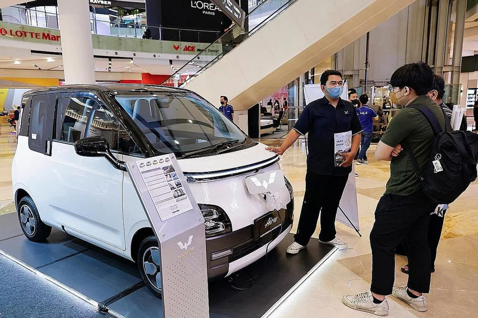 PERTUMBUHAN EKONOMI: Seorang jurujual memberi penerangan tentang kereta elektrik Wuling Air EV kepada pengunjung di pusat beli-belah di Jakarta, Indonesia.- Foto REUTERS
